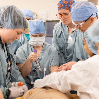 group of medical providers in full scrubs, simulation of code blue